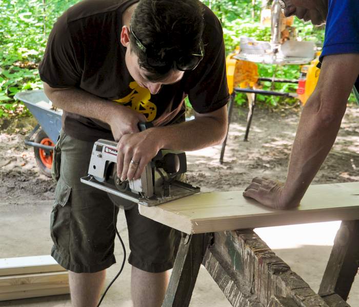 Ehrenamtlicher hilft bei Holzarbeiten