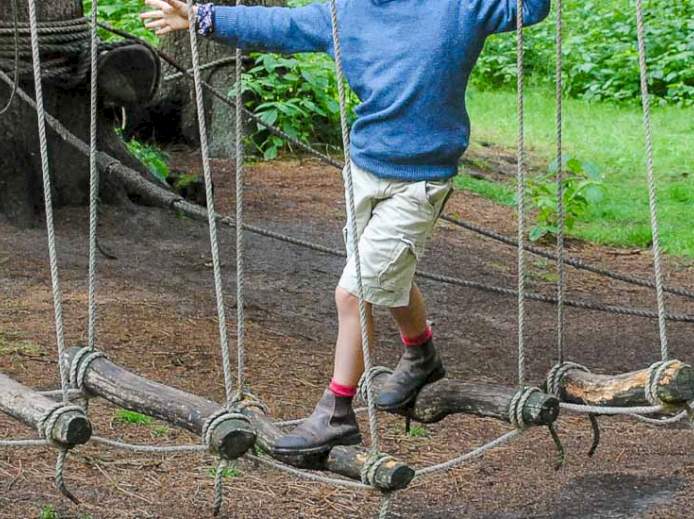 Tiefseilgarten im Wald: Kind balanciert